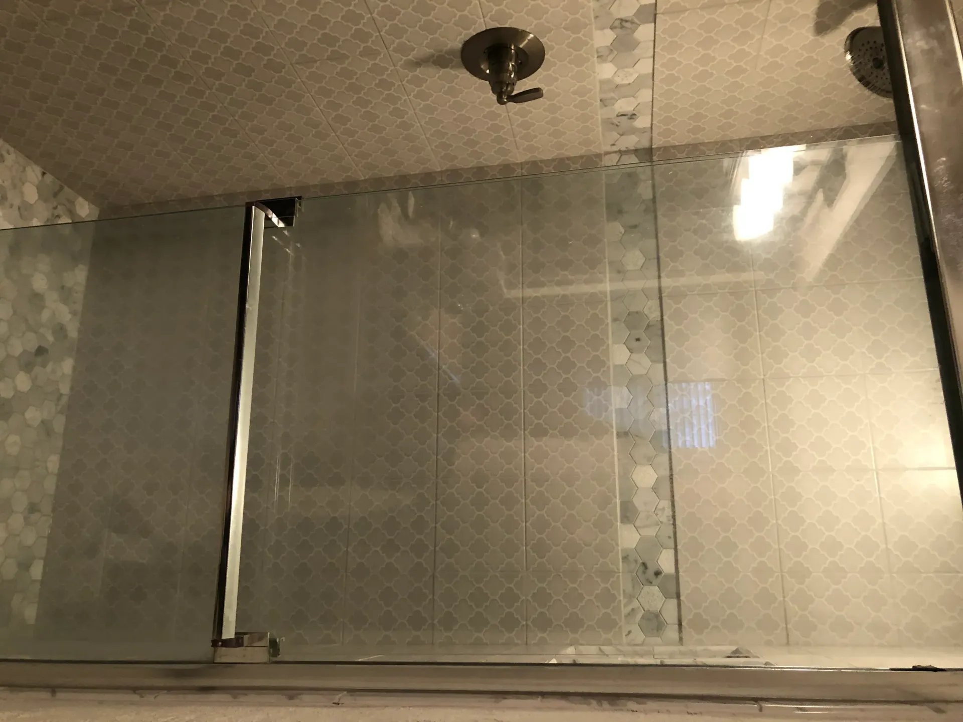 A shower stall with a sliding glass door in a bathroom.