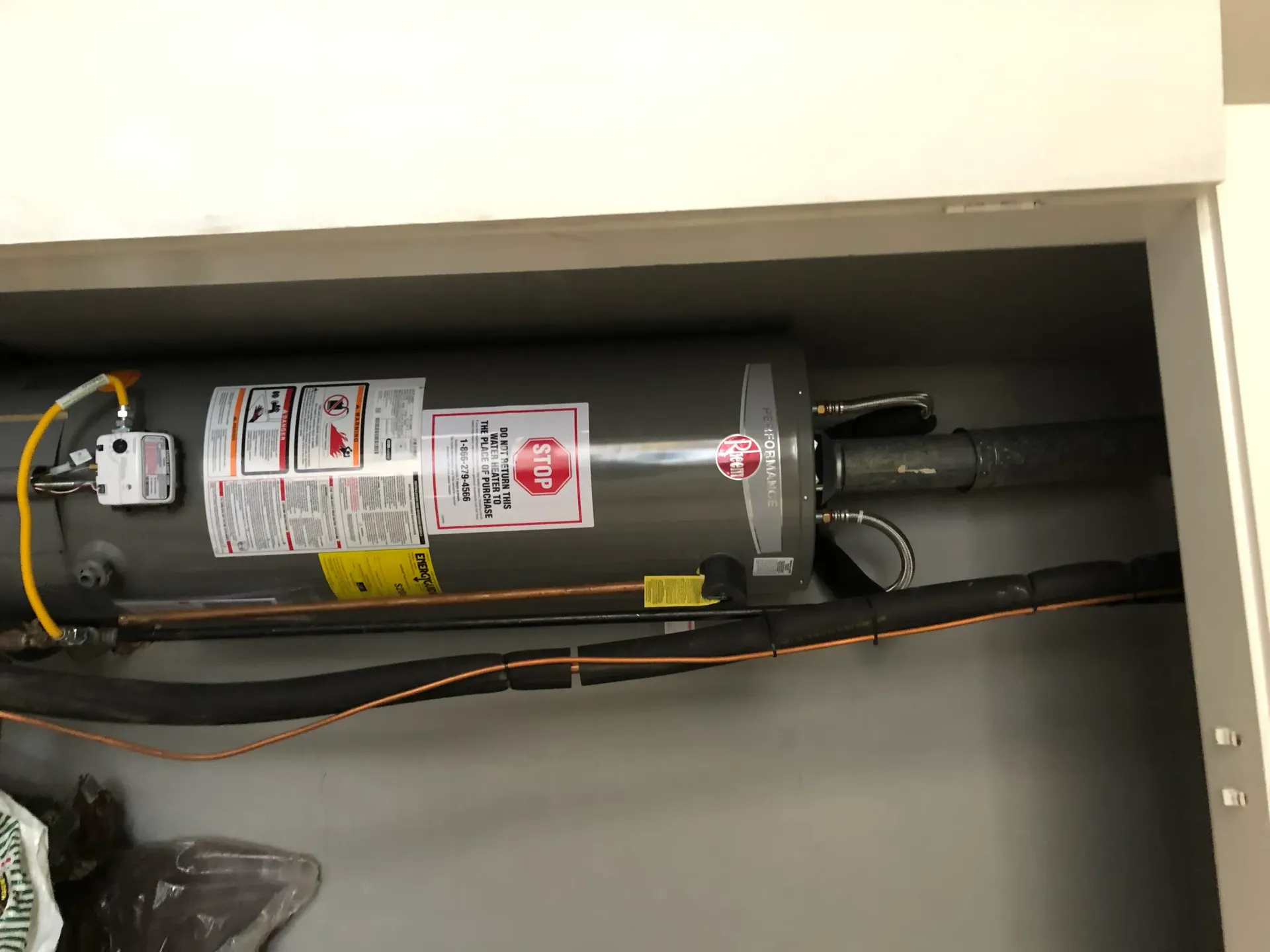 A water heater is sitting inside of a closet.