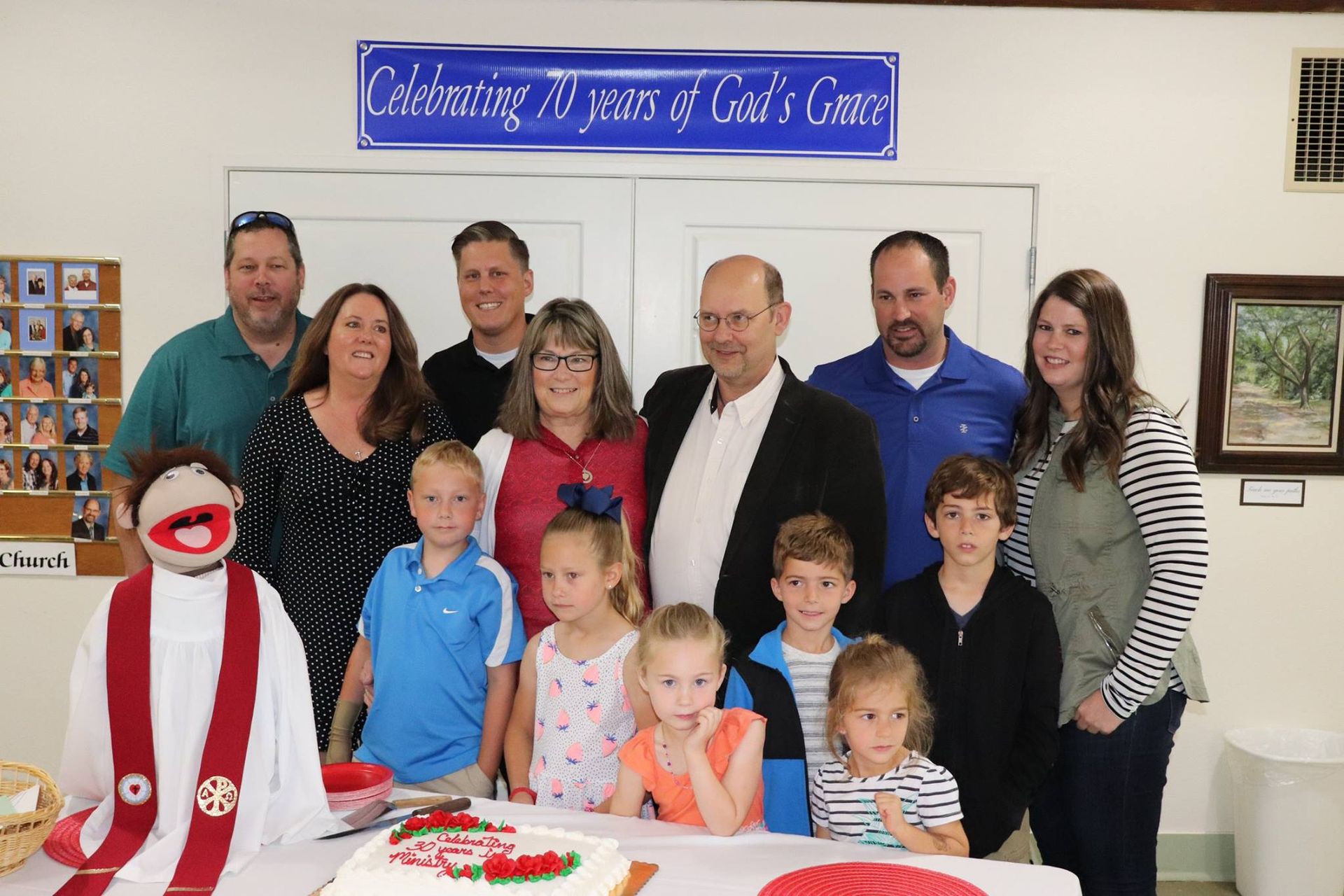 Group of people posing with cake, celebrating 