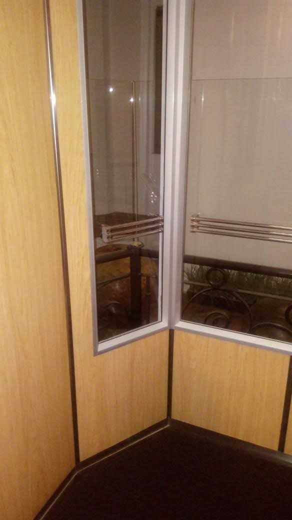 Un rincón de una habitación con una ventana y un espejo.