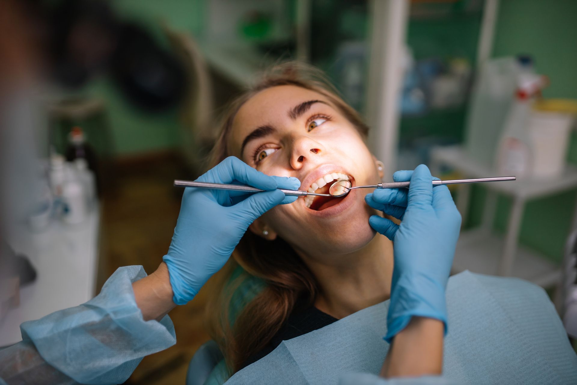 A woman is having her teeth examined by a dentist in a dental office.