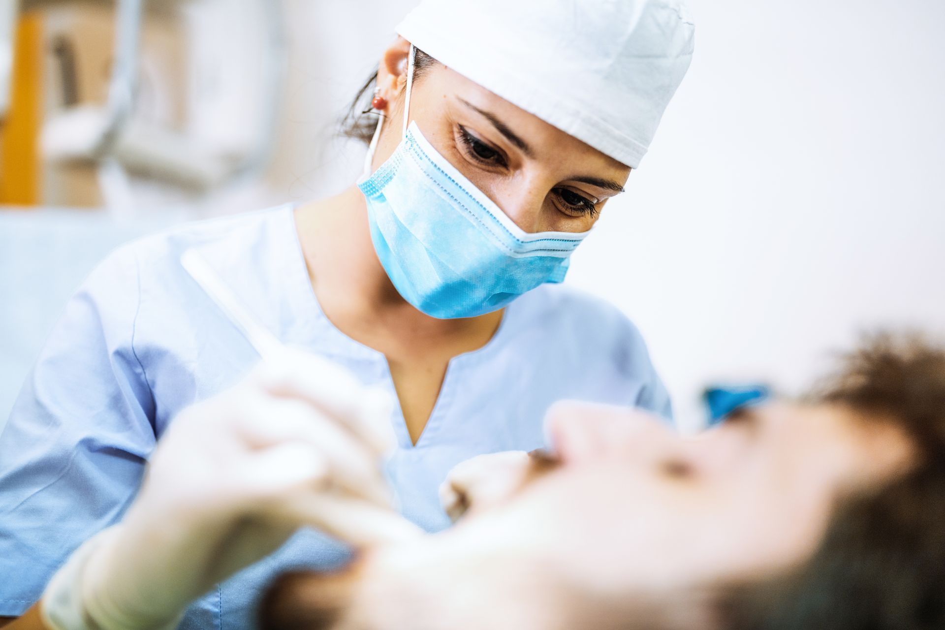 A close-up of a dentist working on a patient’s mouth at the dental clinic.