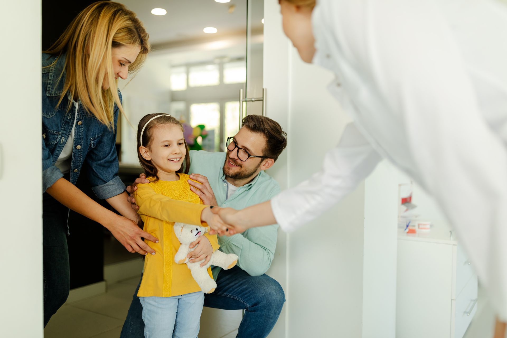 Parents and their daughter meeting with a dentist.