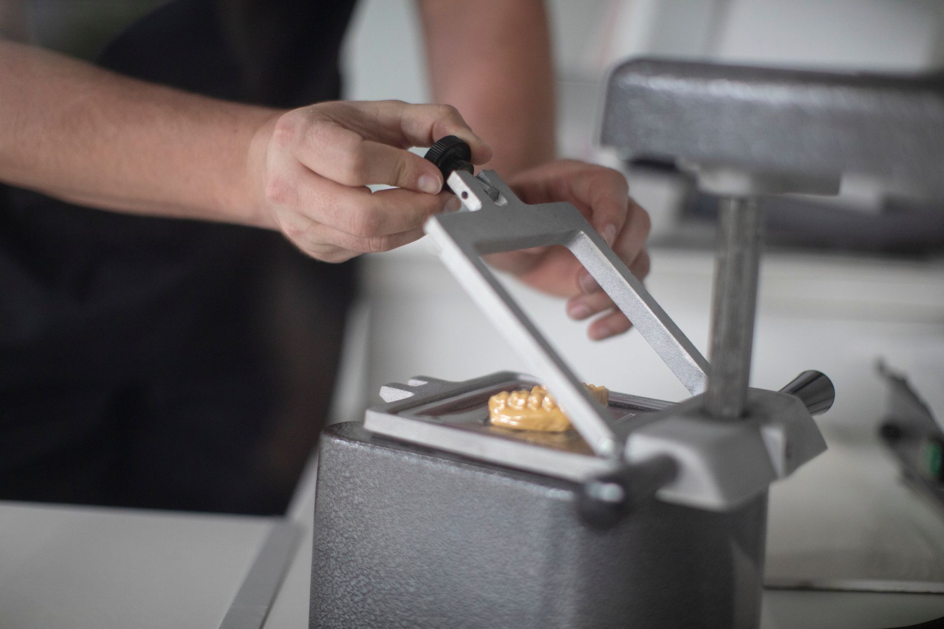 A dentist is working on a model of a person 's teeth.