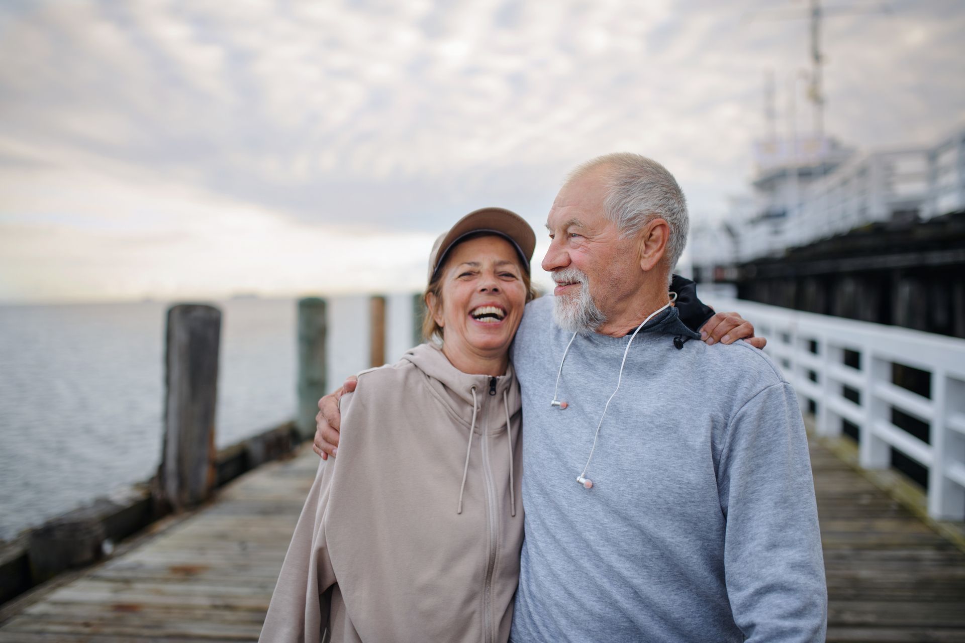 A man and a woman are standing on a pier.