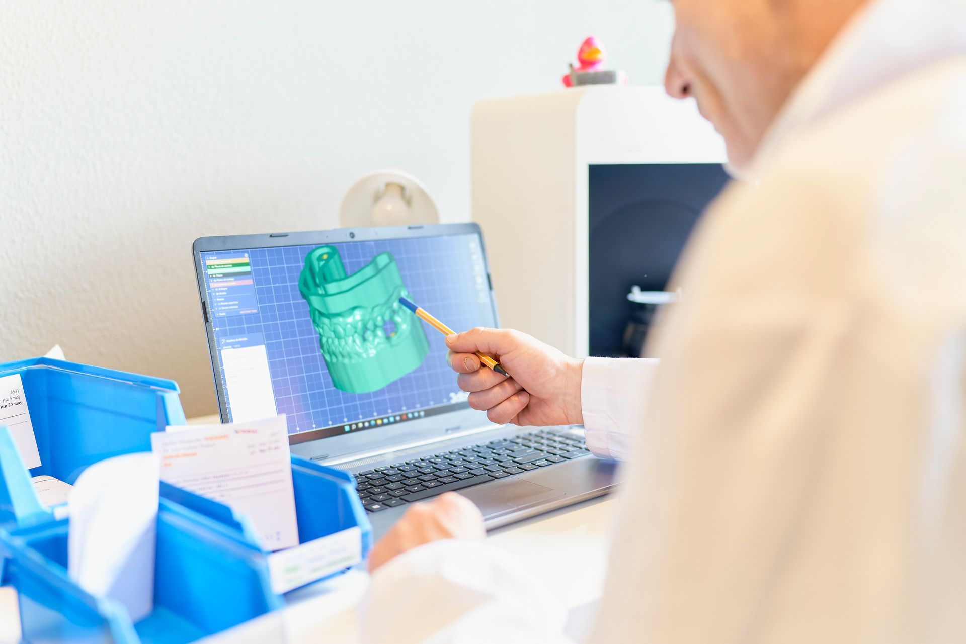 A person is holding a model of a tooth in their hand.
