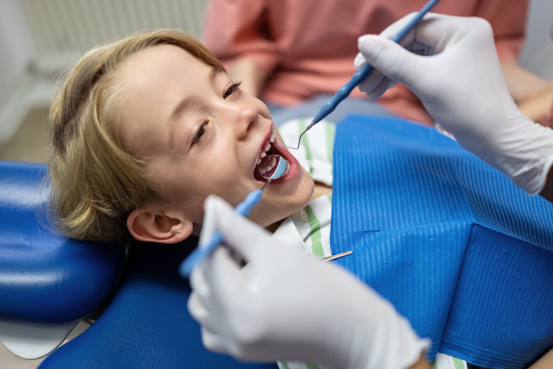 A young boy is undergoing a dental procedure at a paediatric dental clinic. A young boy is undergoing a dental procedure at a paediatric dental clinic.
