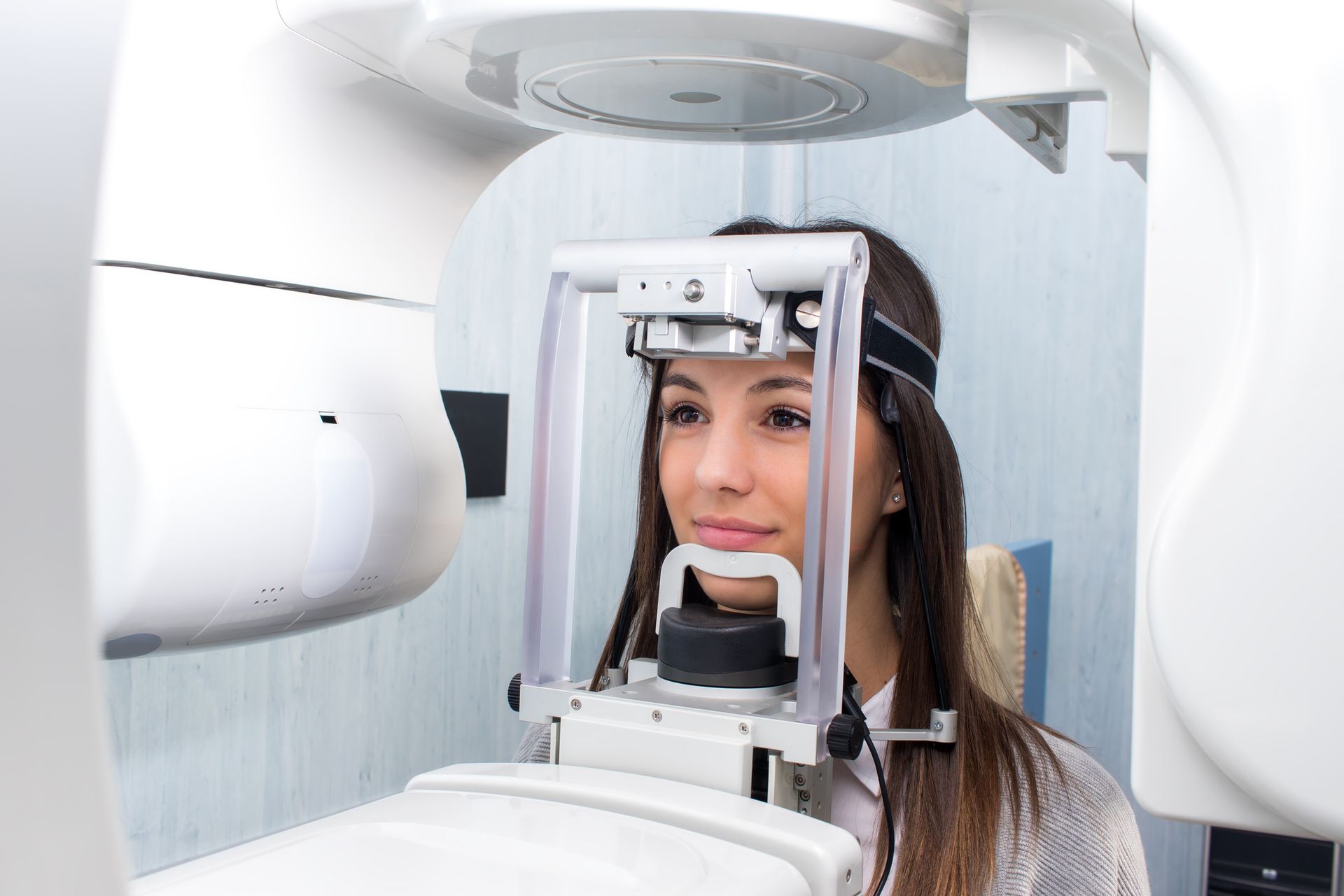 A woman is getting an x-ray of her teeth in a dental office.