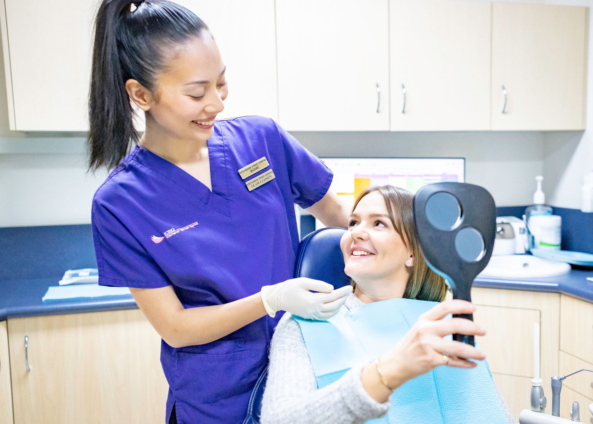 A young woman with curly hair is smiling for the camera.