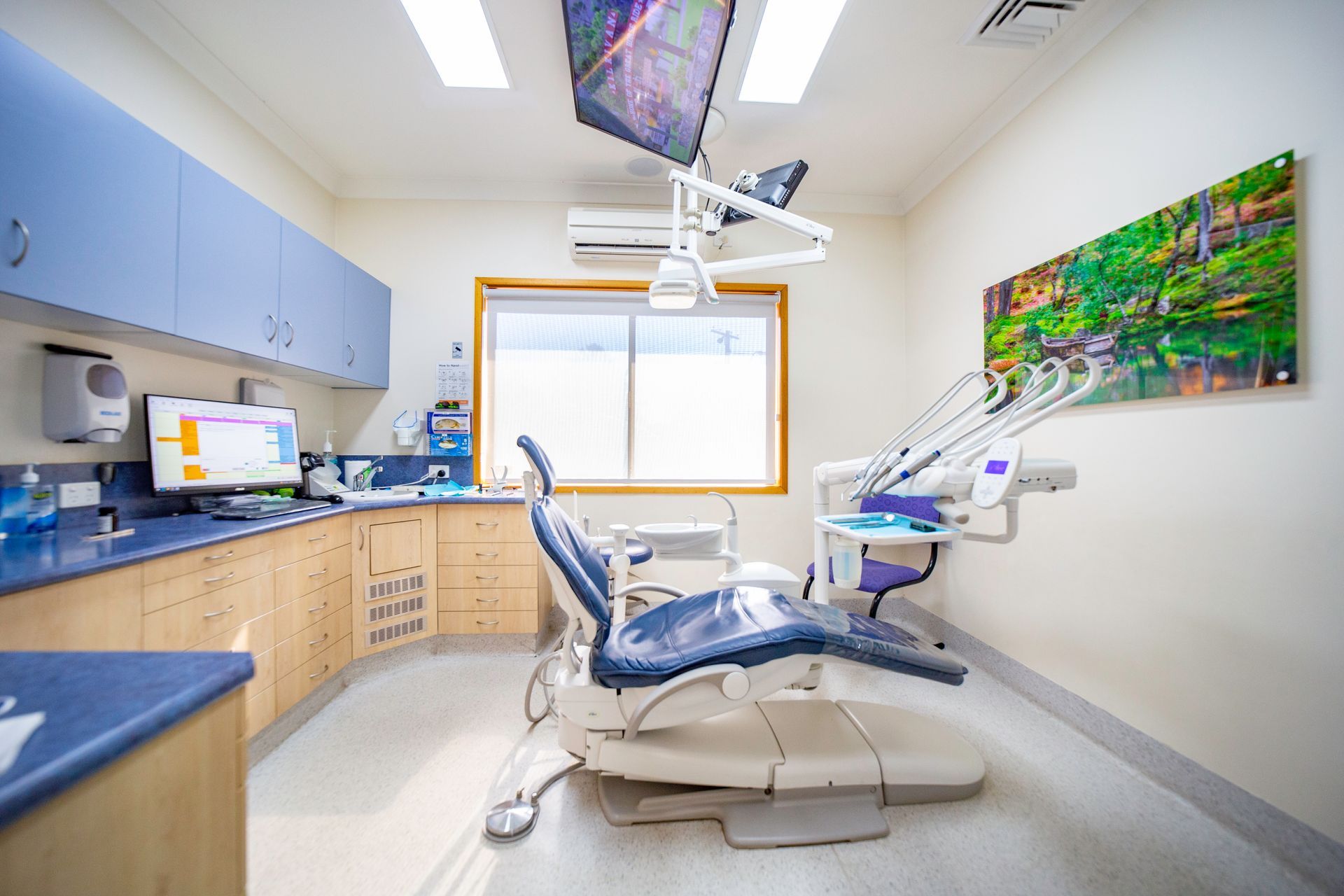 A dentist wearing a mask and gloves is holding a dental tool.