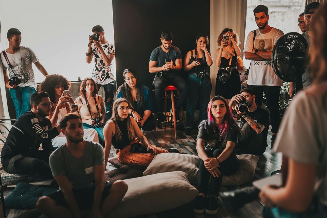 A group of people are sitting in a room watching a presentation.
