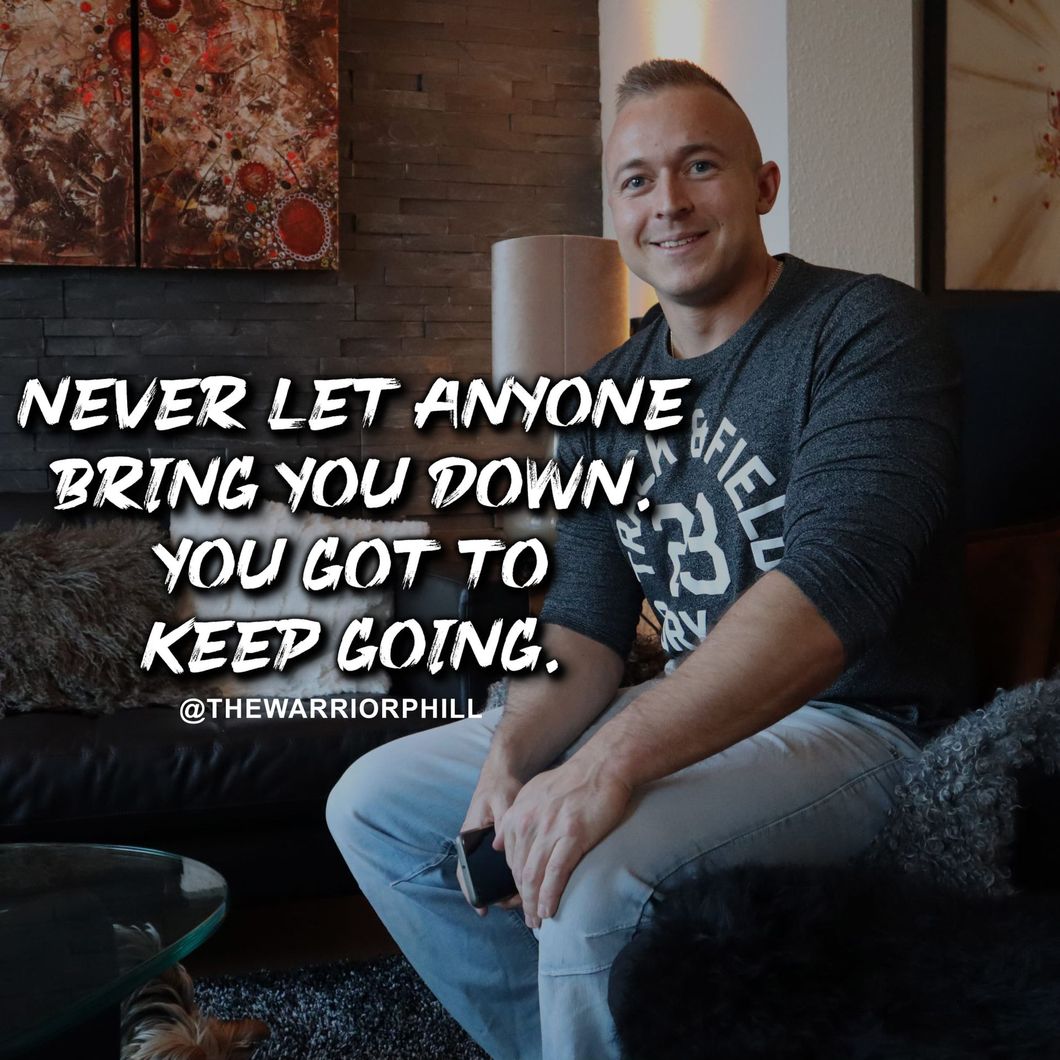 A man is sitting on a couch with a quote that says never let anyone bring you down you got to keep going