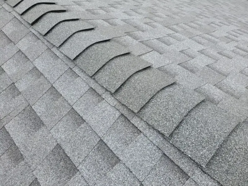 Gray asphalt shingle roof, close up detail of ridge cap.