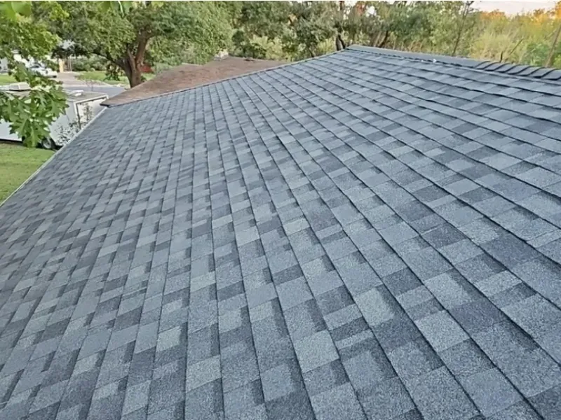 Gray asphalt shingle roof on a house, angled view.