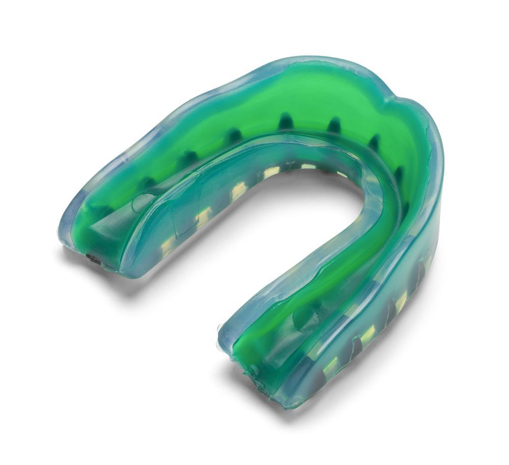A Green and Blue Mouth Guard on a White Background — Dental Prosthetics By Richard & Cindy In Oxenford, QLD