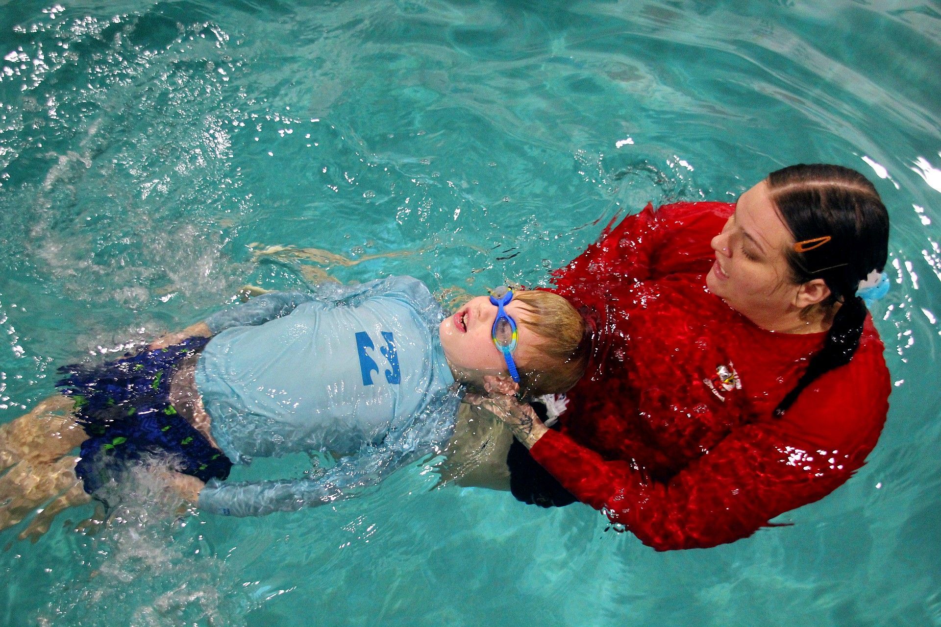 Swimming lessons a young girl is swimming in a pool with a paddle.