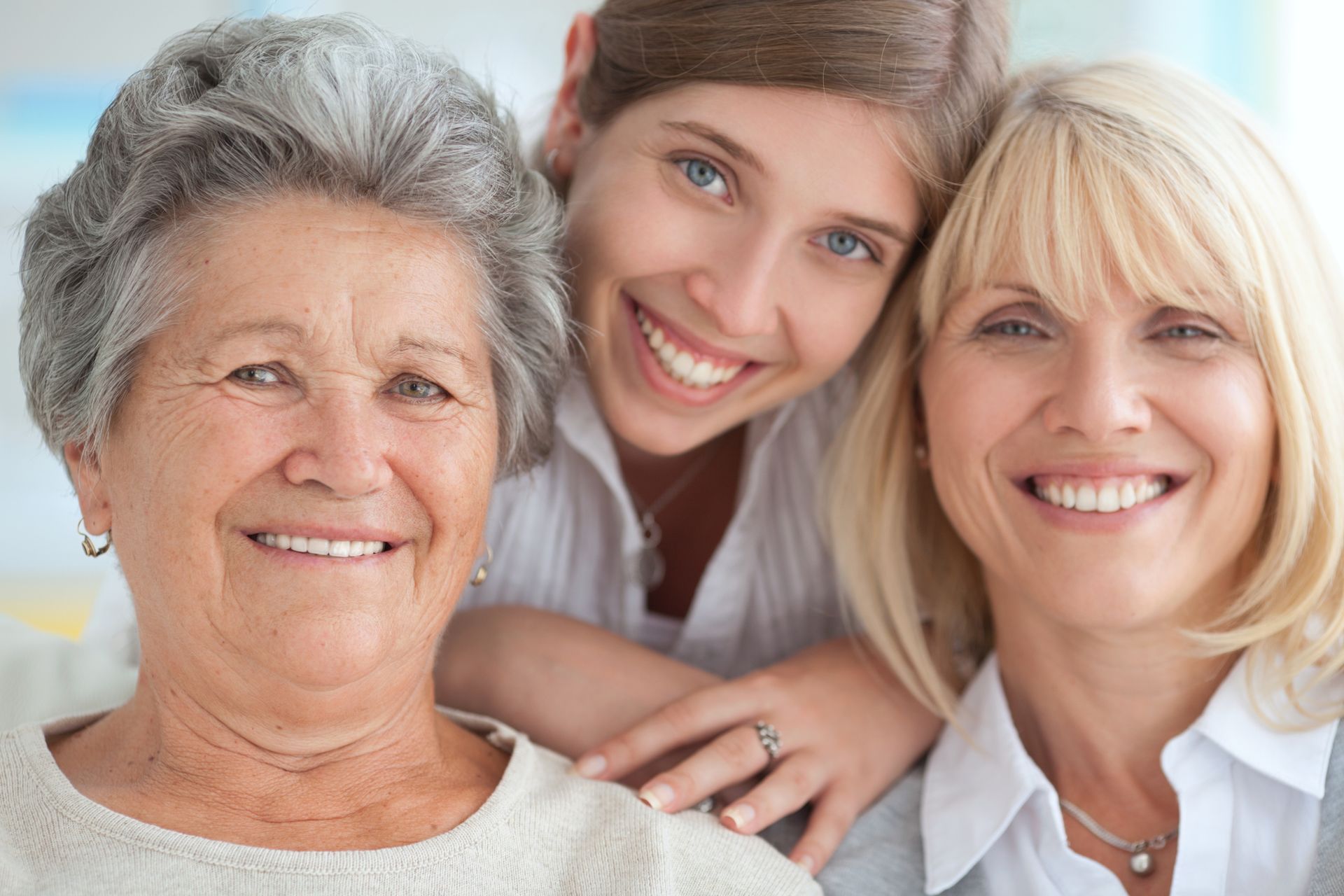 Three women are posing for a picture together and smiling for the camera.