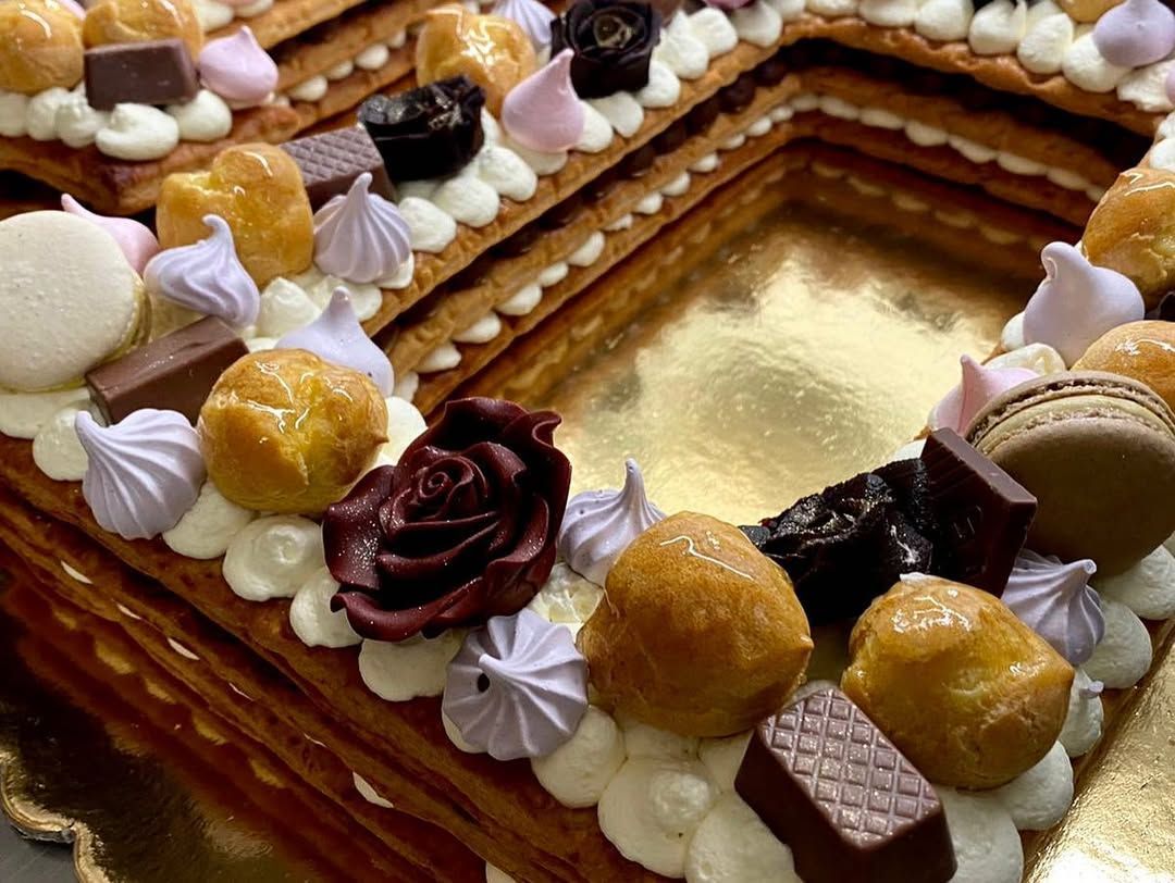 Dessert di pasta frolla con crema, dolci e dettagli di cioccolato.