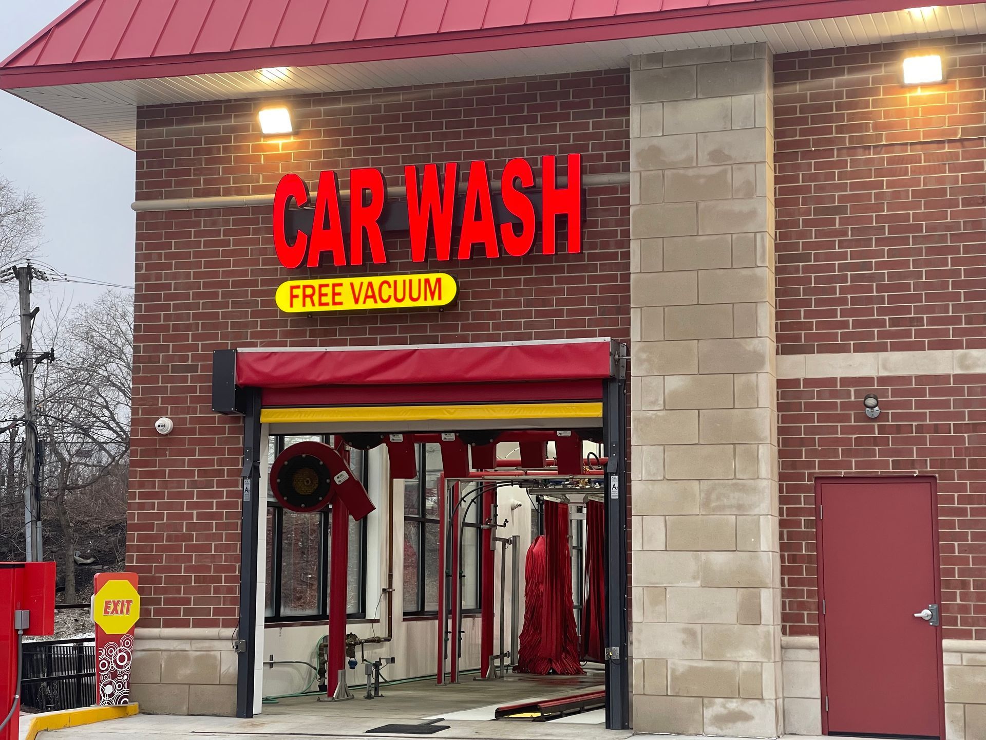 A car wash with a red awning and a free vacuum