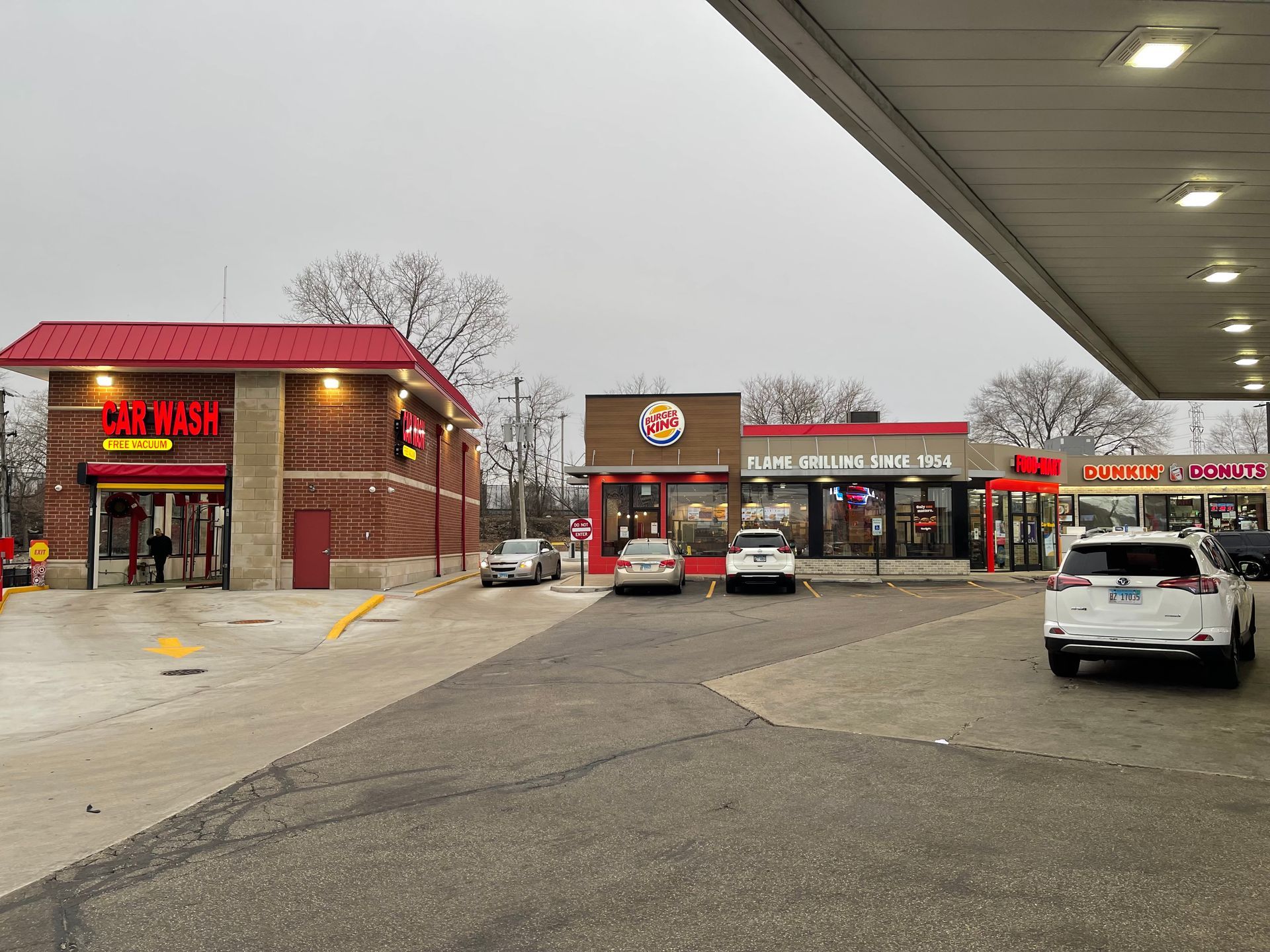 A bunch of cars are parked in front of a burger king restaurant.