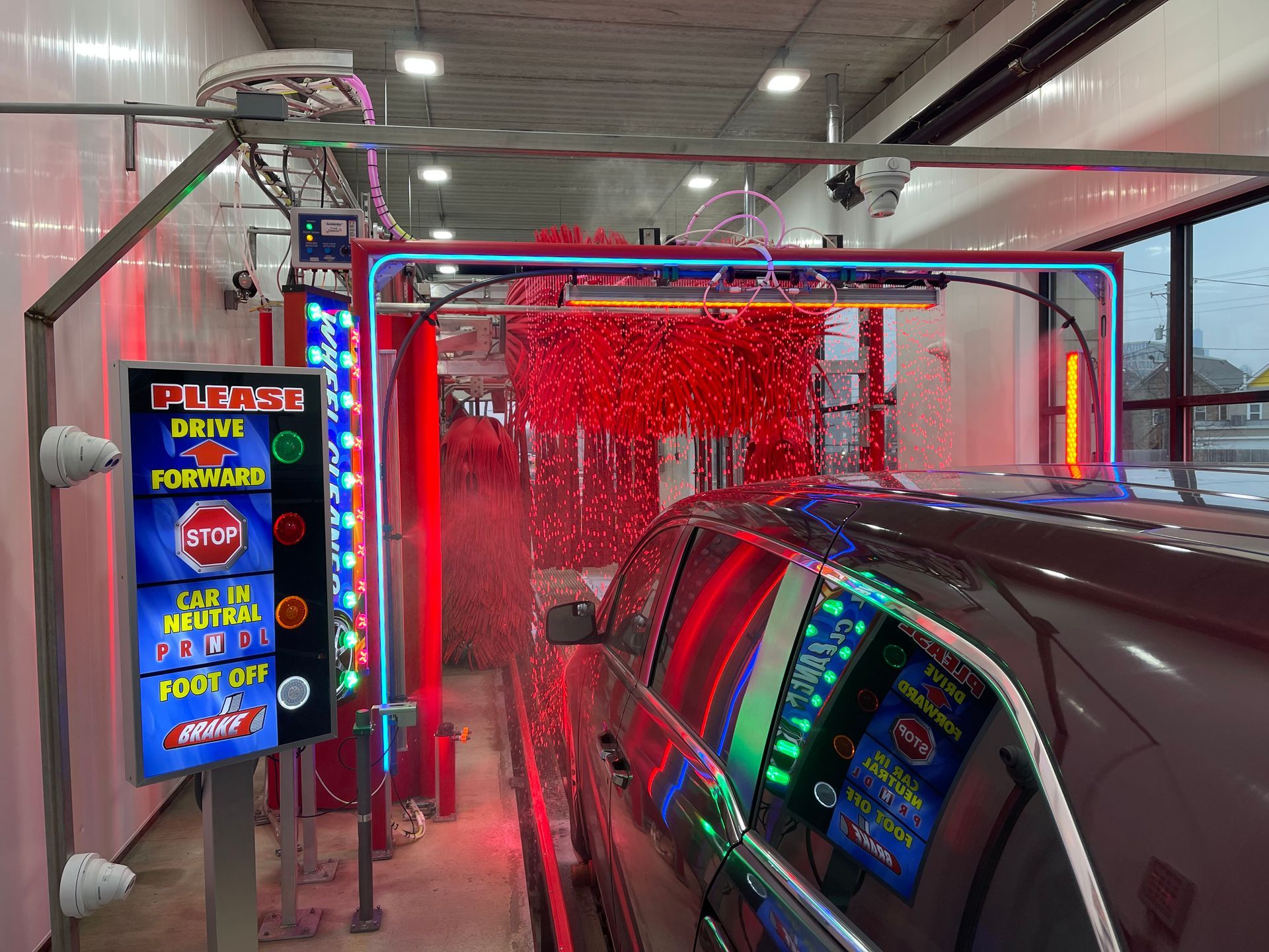 A car is going through a car wash with a sign that says ' push ' on it.