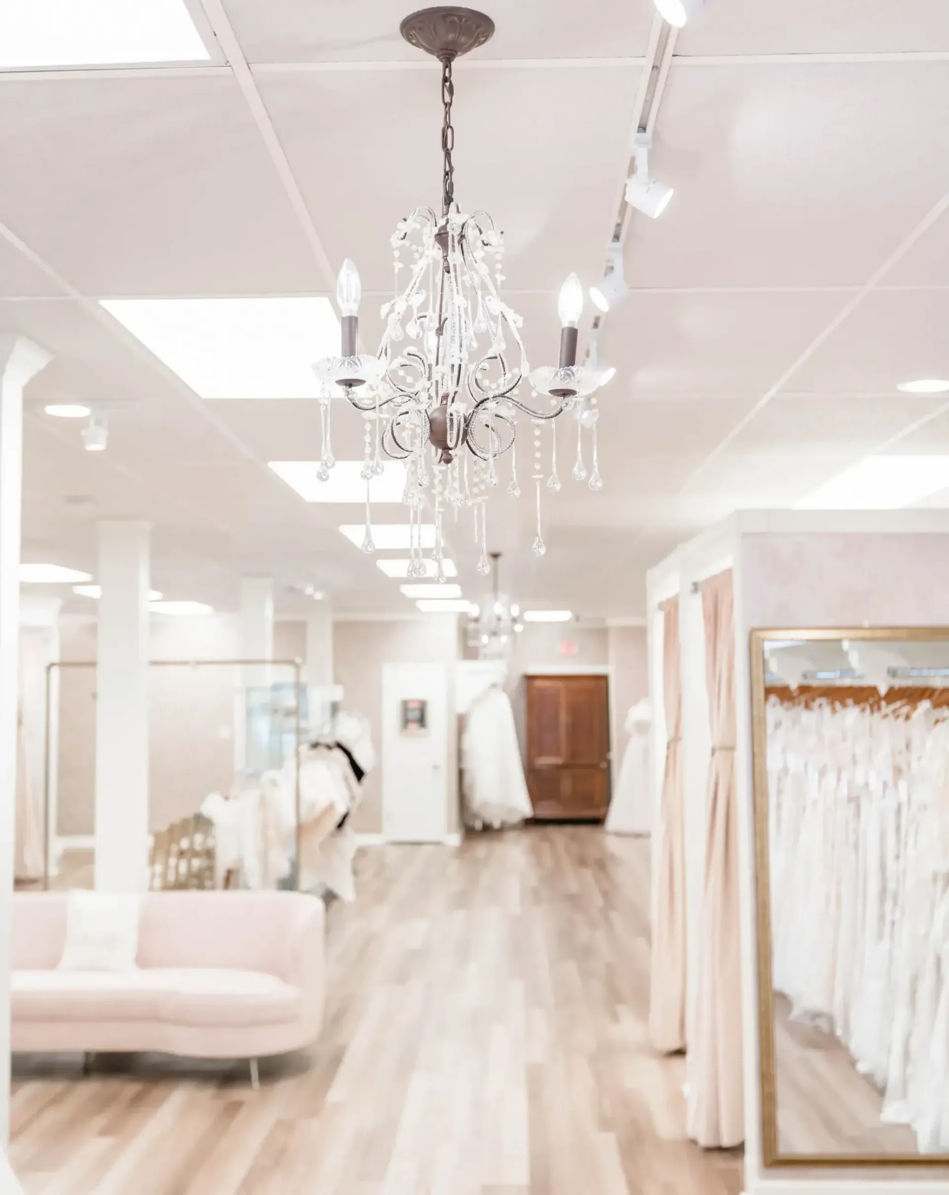 Woman wearing a white strapless wedding gown, smiling, in a studio setting.