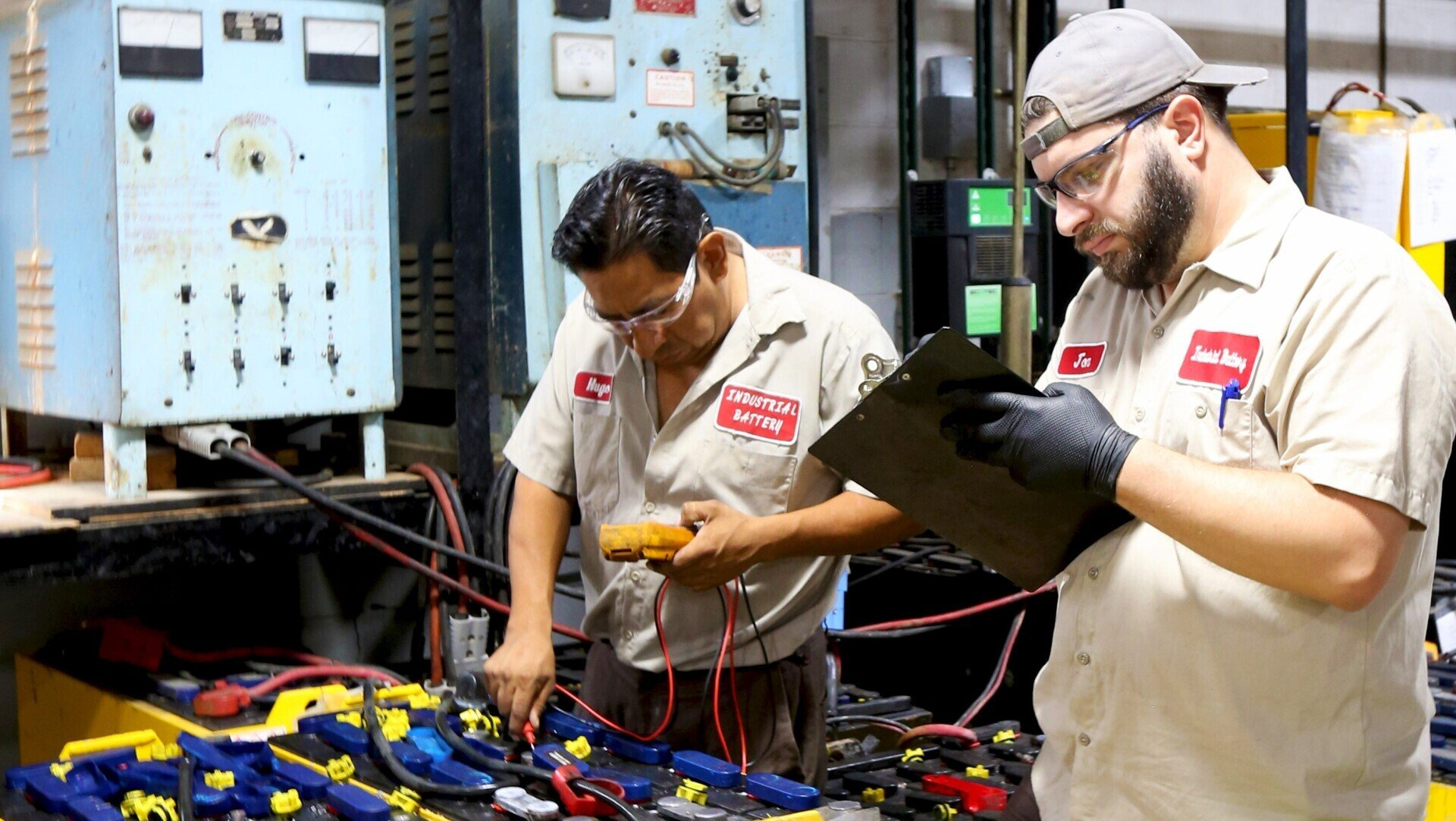 Two men are working on a battery in a factory.