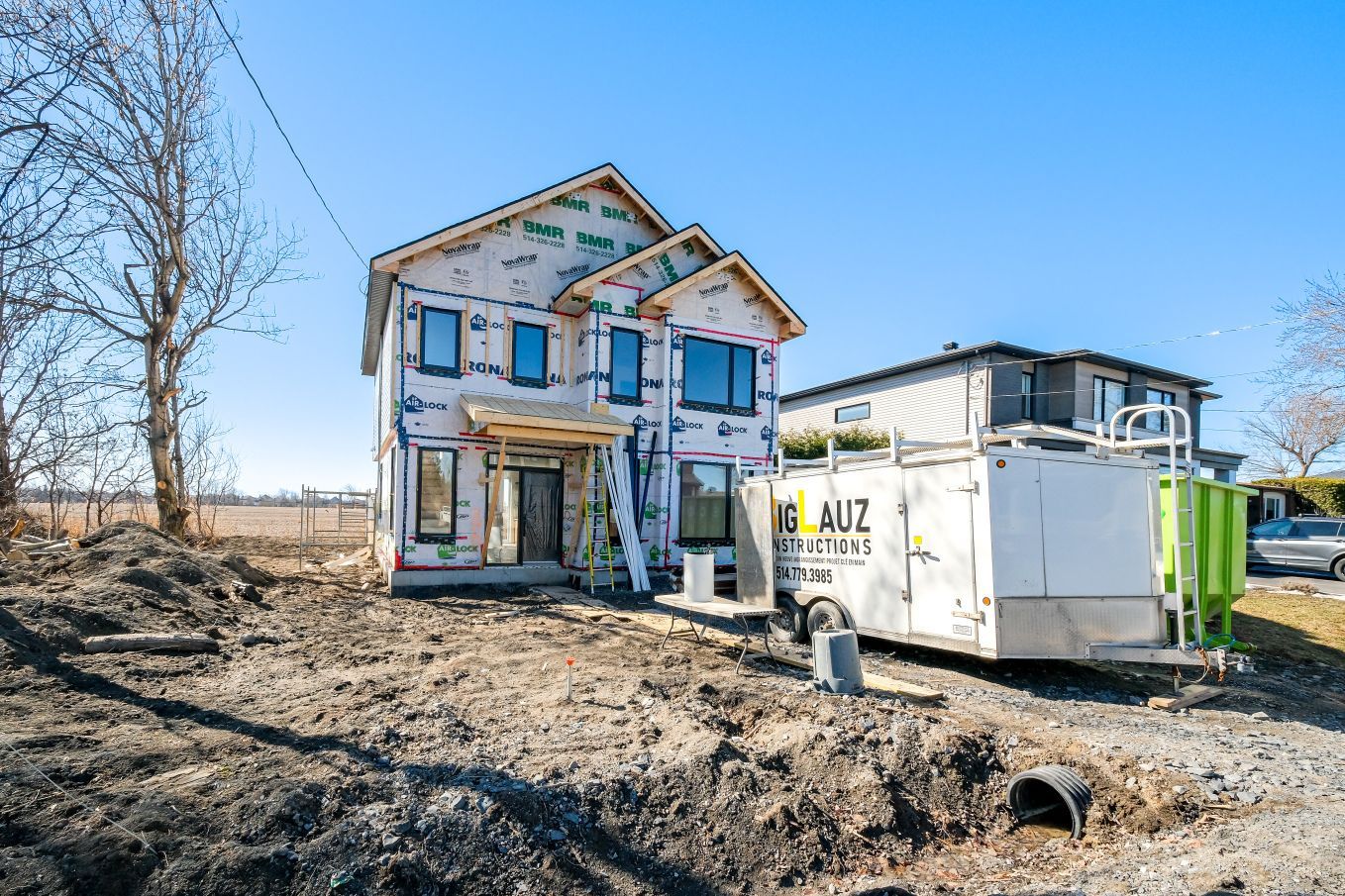Une maison en construction avec une caravane garée devant.