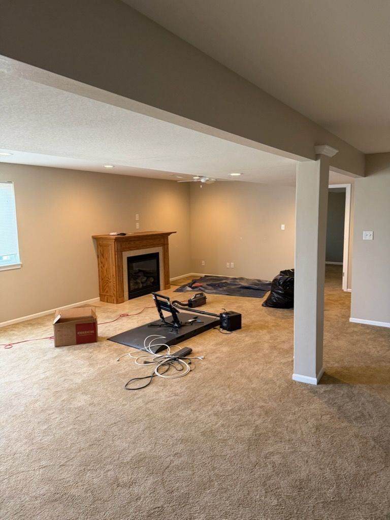 Woman in straw hat smiles, holding wine glass near a lake.
