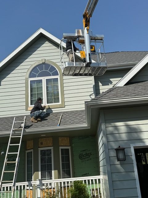 Woman in straw hat smiles, holding wine glass near a lake.
