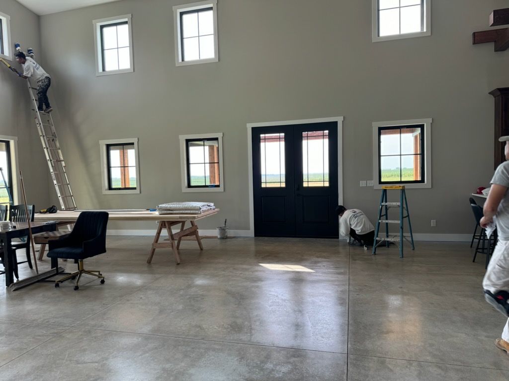 Woman in straw hat smiles, holding wine glass near a lake.