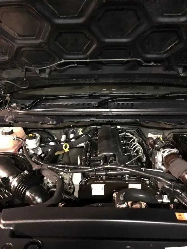 A close up of a car engine with the hood open.