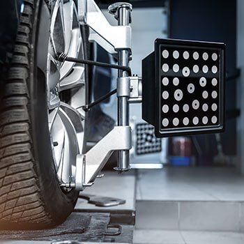 A car wheel is being aligned by a machine in a garage. West Babylon, NY | ADAS LI