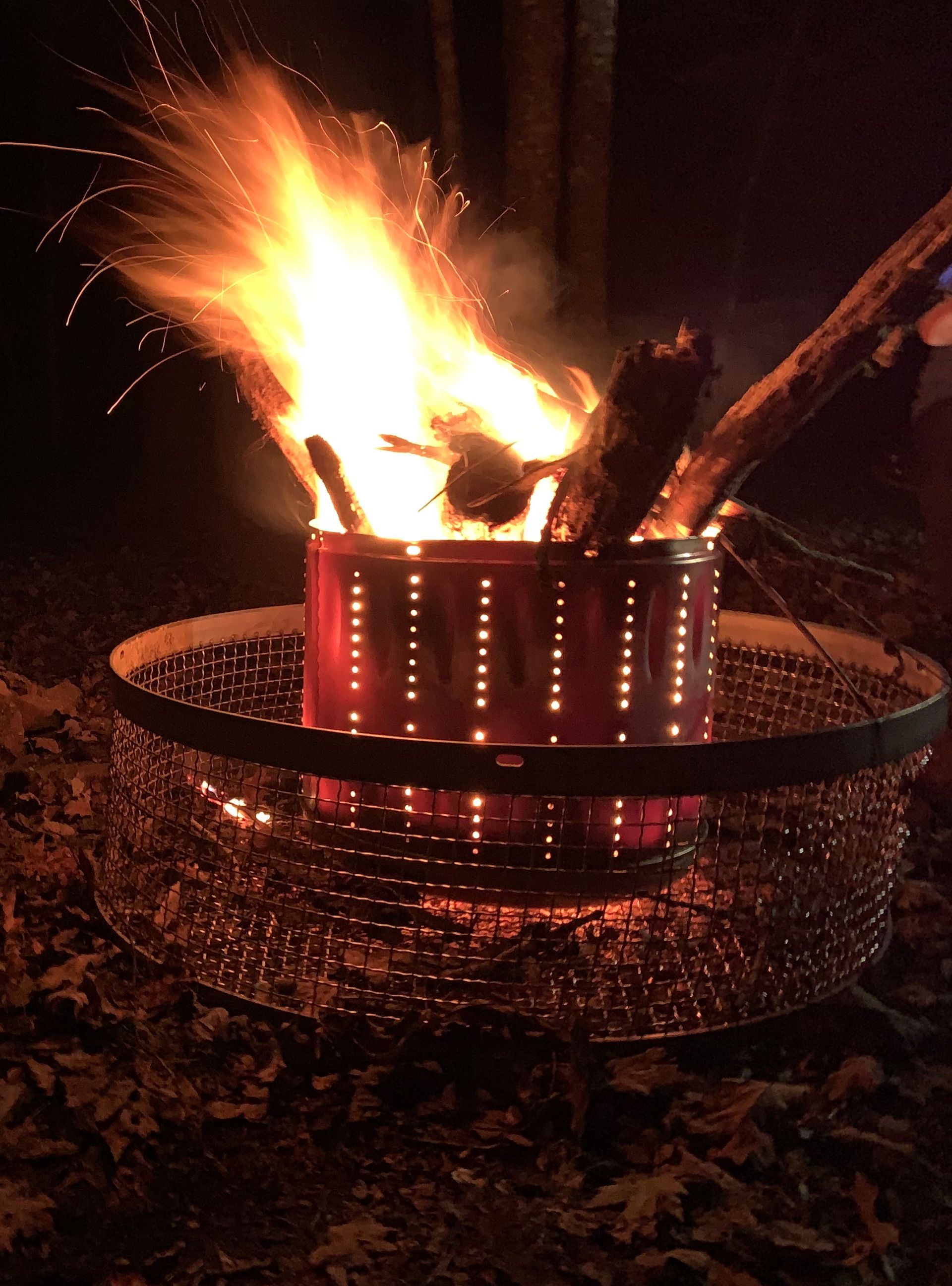 A fire is being lit in a can with sparks coming out of it