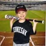 A young boy is holding a baseball bat on a baseball field.