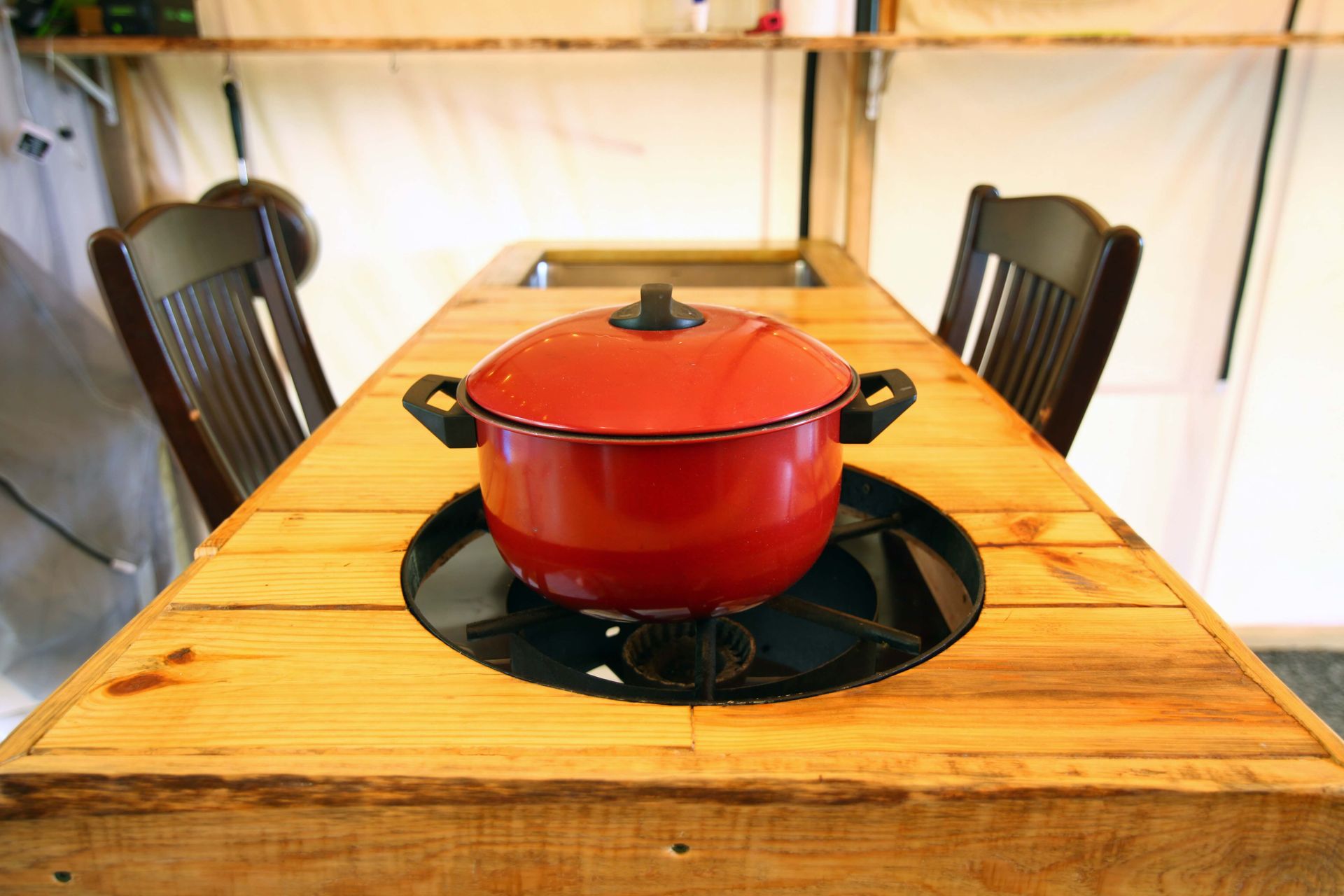 A wooden table with a pot on top of it