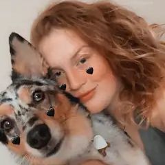 A woman is hugging a dog with hearts on her face.