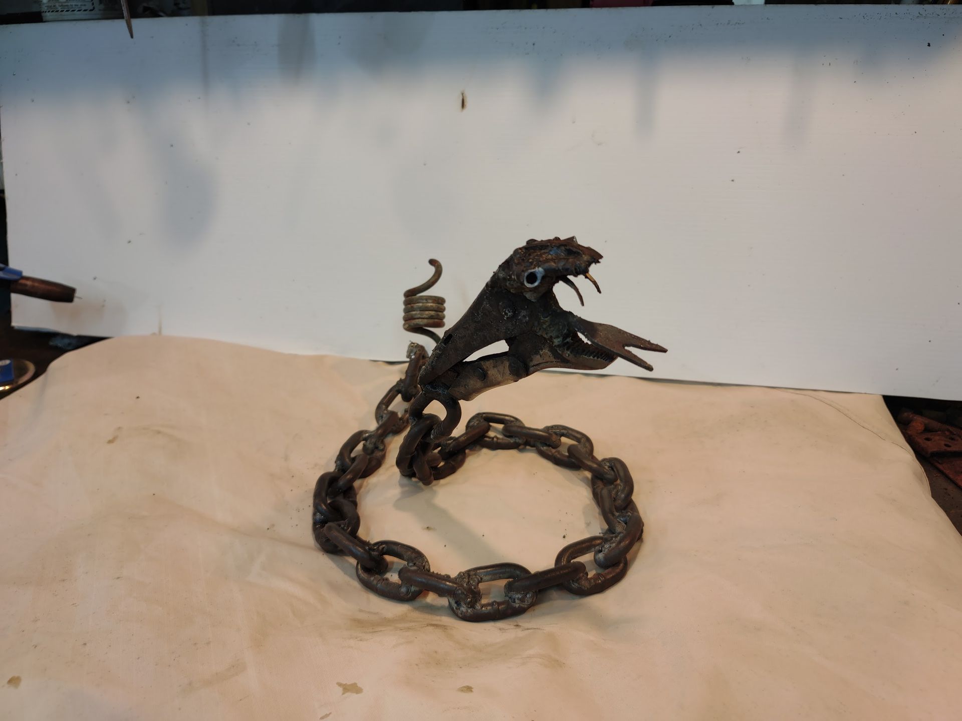 A snake made out of chains is sitting on a table