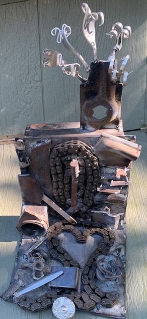 A sculpture made out of junk is sitting on a table.