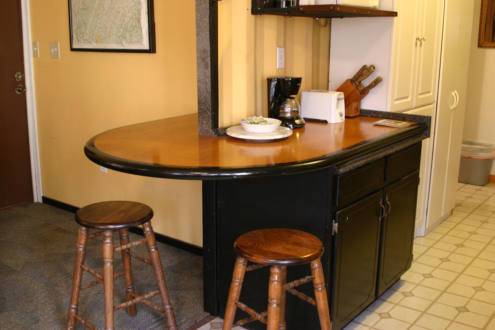A kitchen with a table and two stools