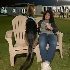 A woman is sitting on a bench with a dog.