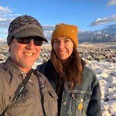 A man and a woman are posing for a picture in the snow.