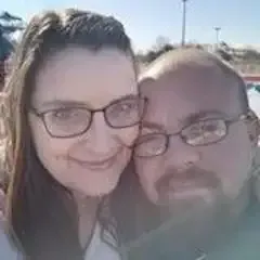 A man and a woman wearing glasses are posing for a picture.