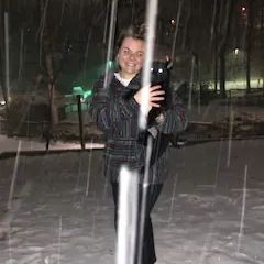 A woman is taking a selfie in the snow at night.