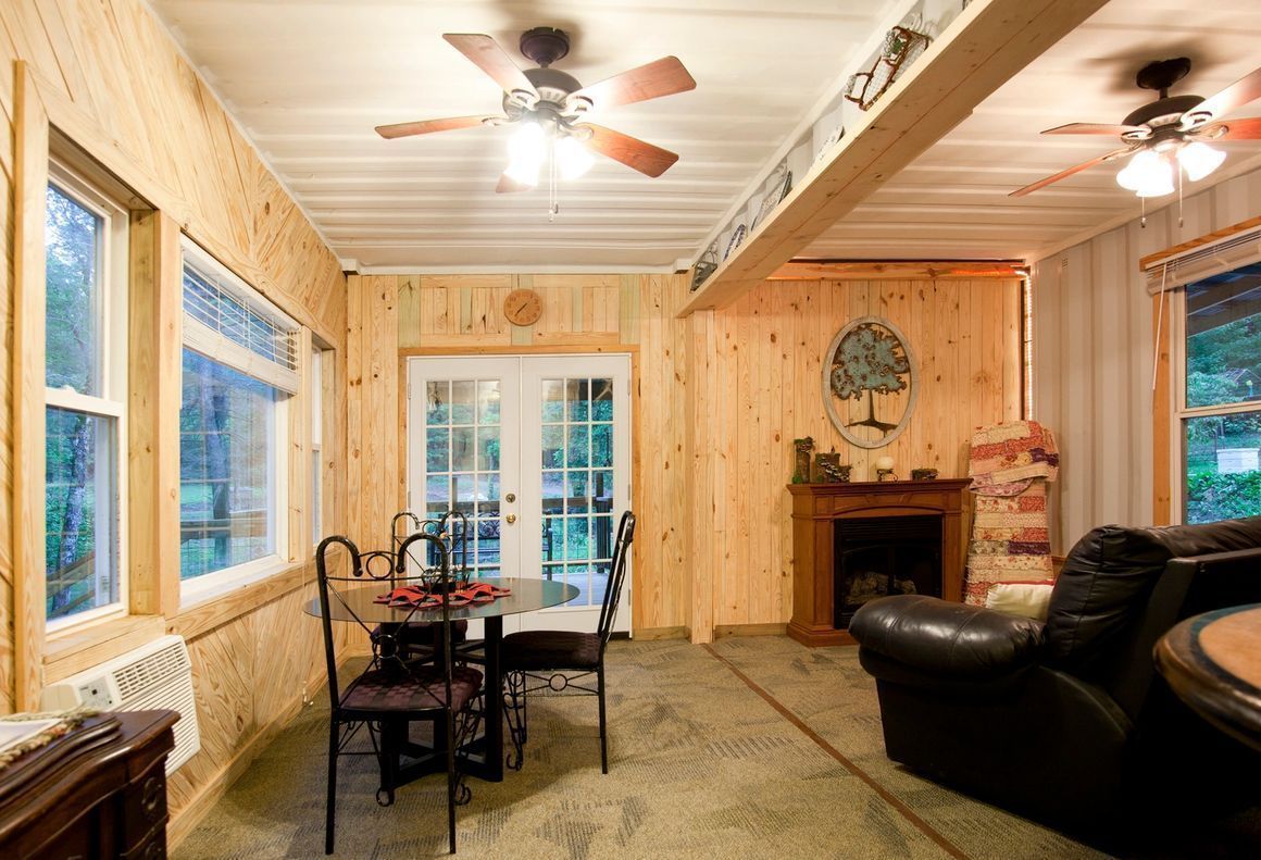 A living room with a table and chairs and a ceiling fan.