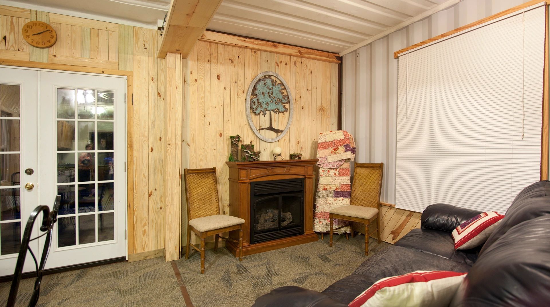 A living room with a couch , chairs and a fireplace.