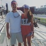 A man and a woman are posing for a picture in a stadium.