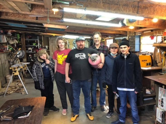 A group of people posing for a picture in a garage