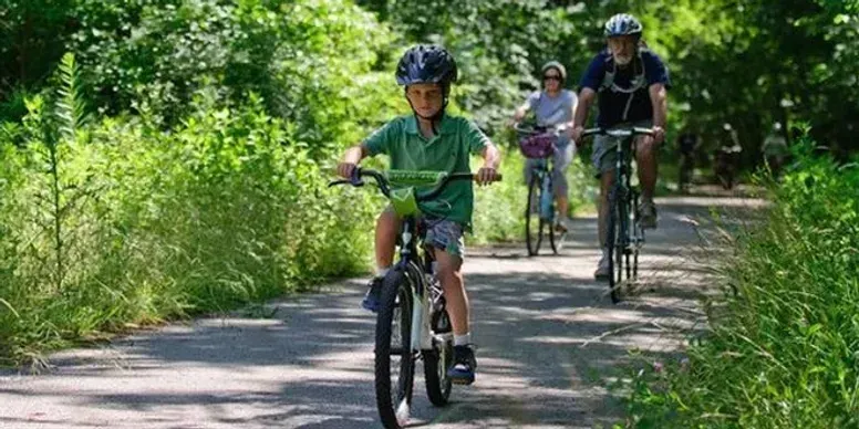 A group of people are riding bicycles down a path.