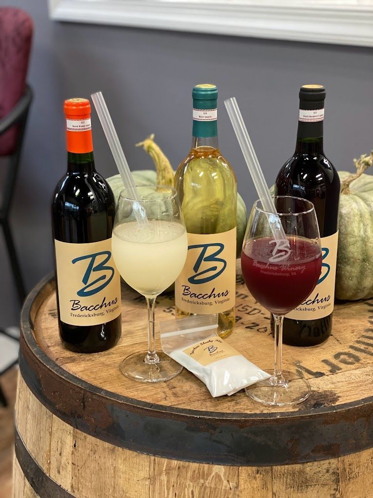 Three bottles of wine and three glasses of wine are sitting on a wooden barrel.